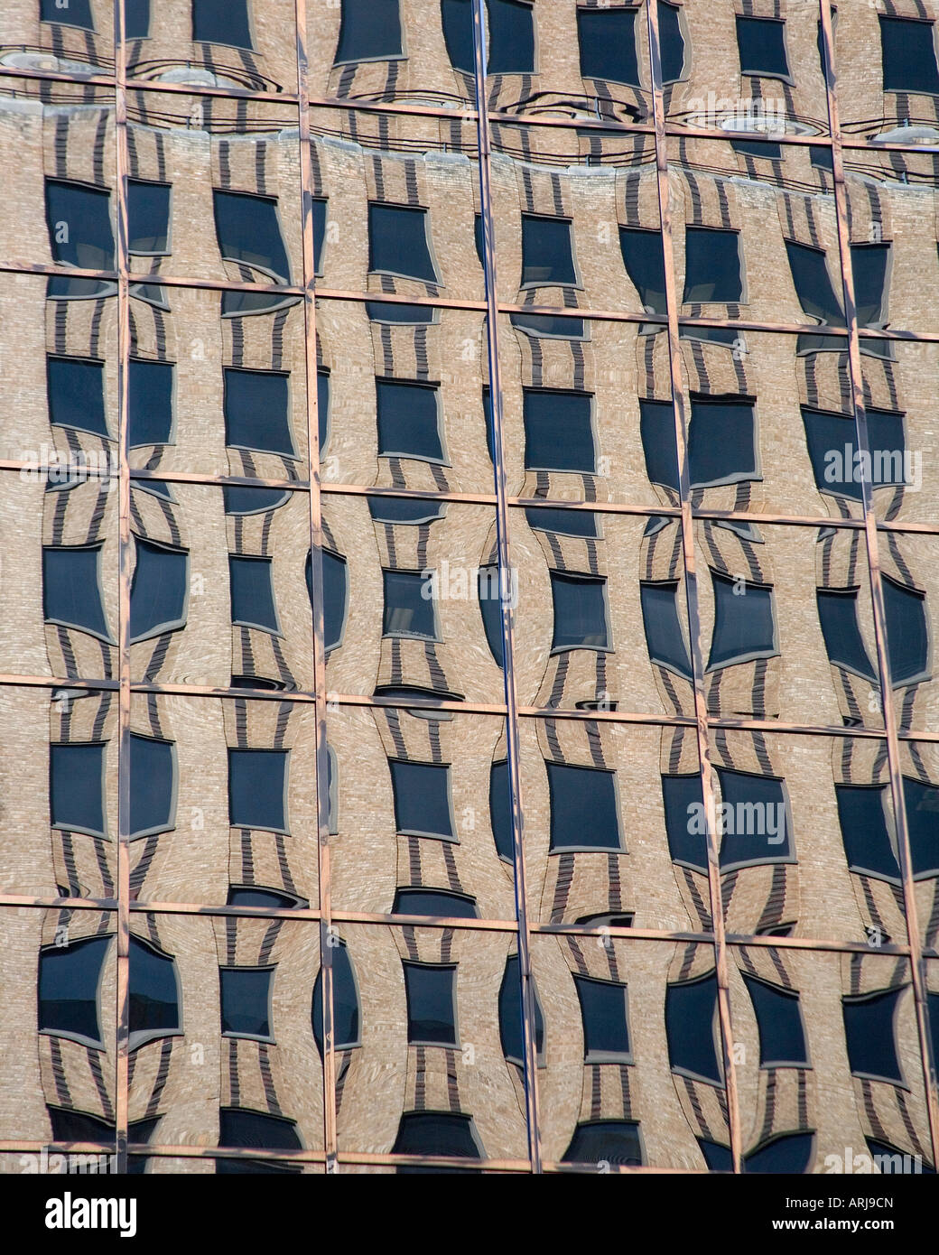 Classic brick office building reflected in a mirrored wall Stock Photo