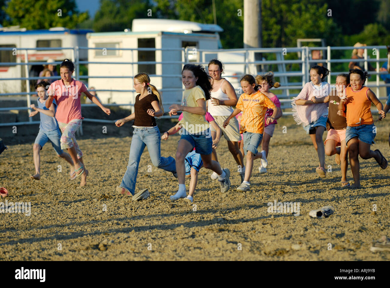Children run into the middle of a rodeo ring as part of the festivities of a rodeo Stock Photo