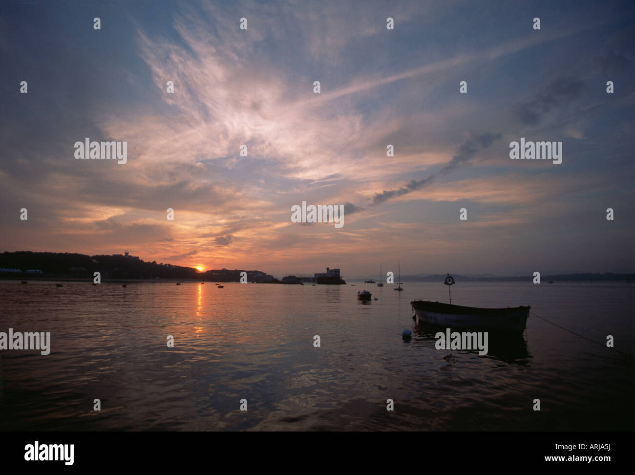 Fishing boat at anchor with French sunset in background Stock Photo - Alamy
