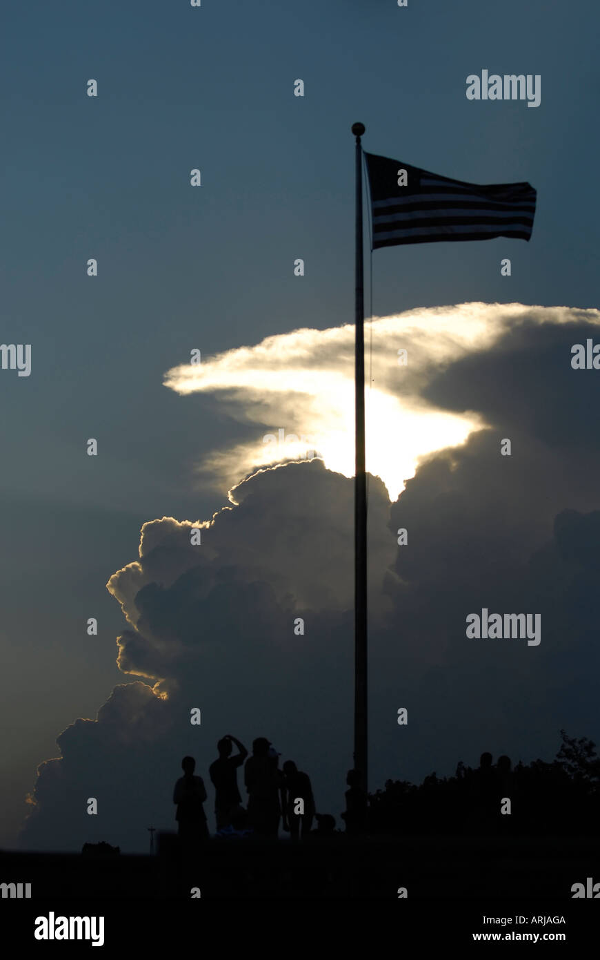 Sunset and clouds with people and the United State Flag Stock Photo