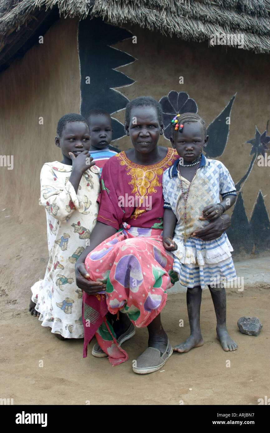 Dinka woman with her children in front of mud house, Sudan Stock Photo ...