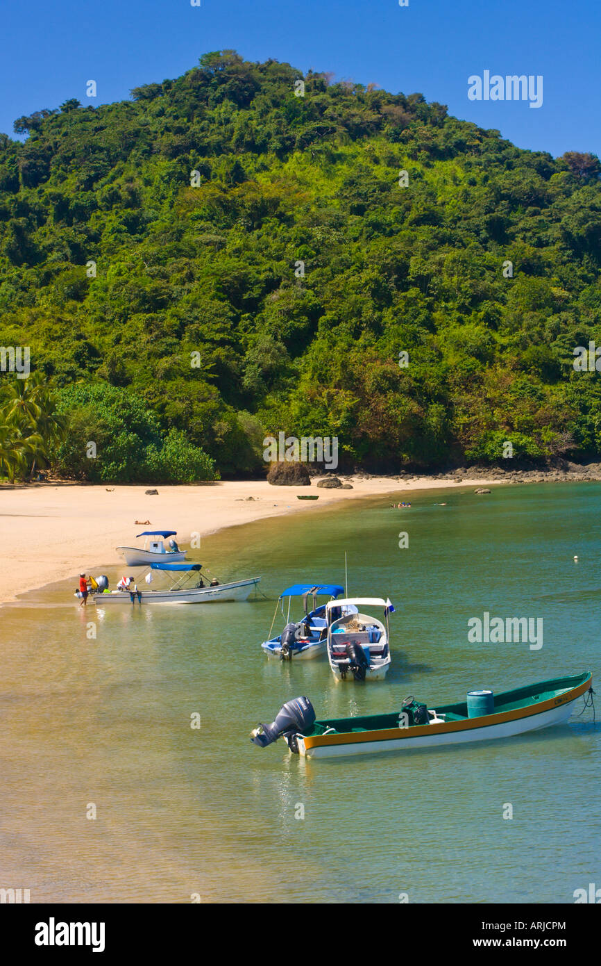 Tourist boats moored on the beach at the rangers station Isla Coiba Panama Stock Photo