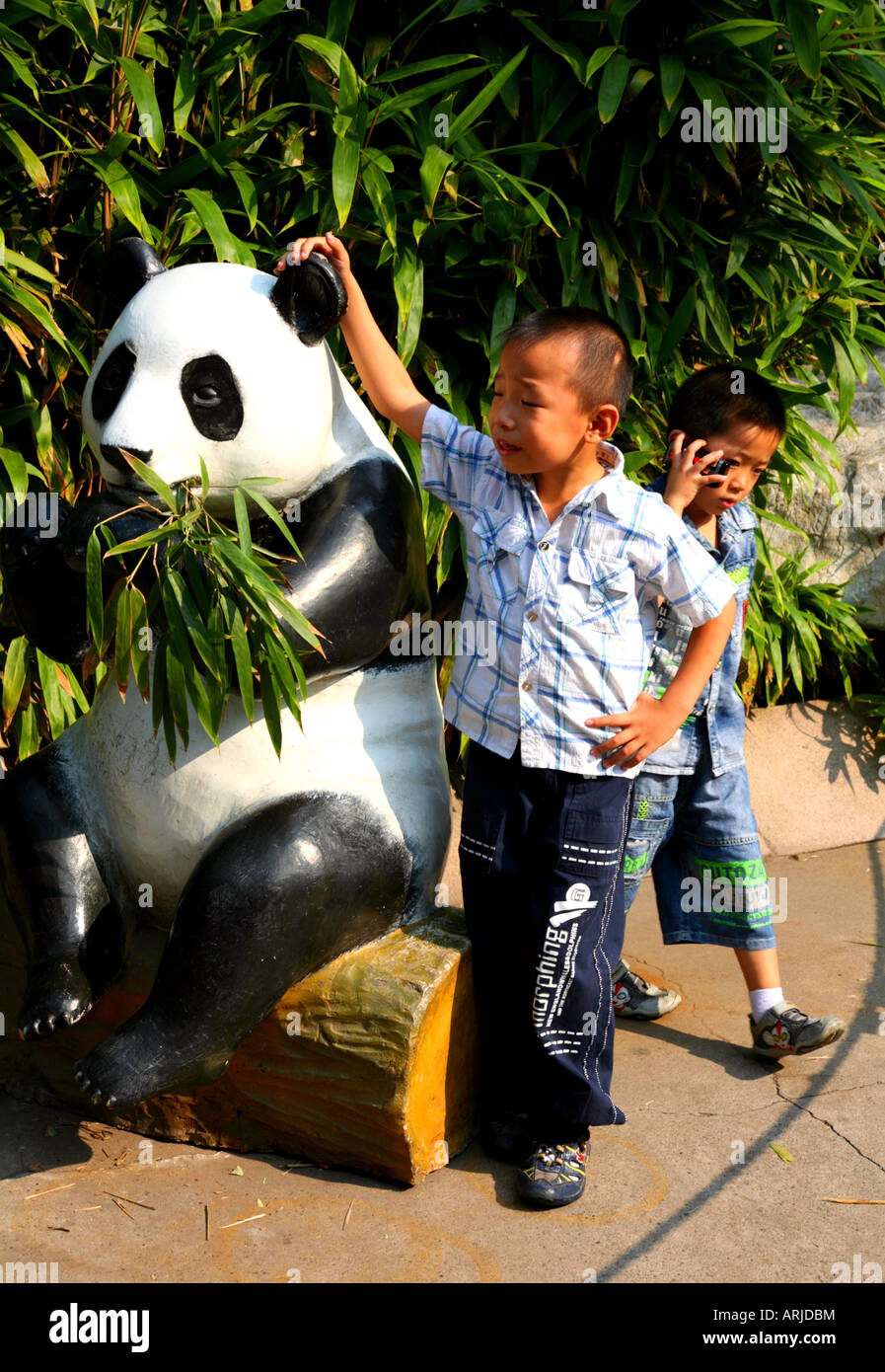 Young boy posing beside a model of a Giant Panda Bear, Beijing, China. Stock Photo
