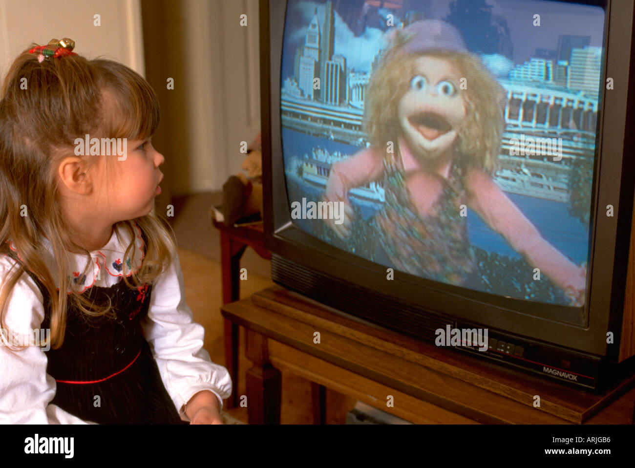 Preschool girl age 5 watching Sesame Street television show at home