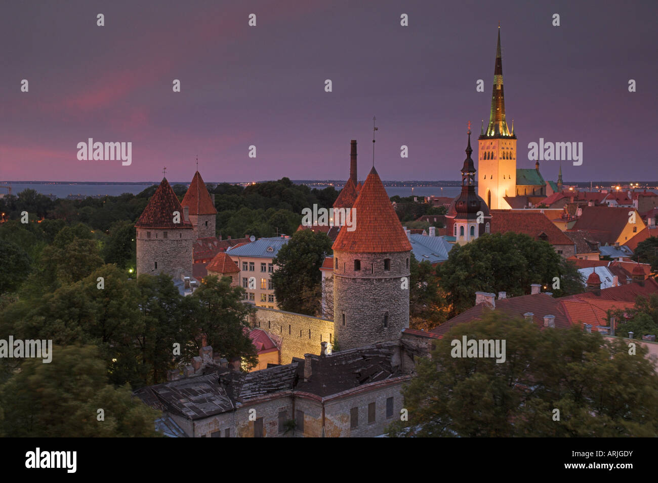 Medieval town walls, defence towers and spire of St. Olav's church at sunset, Tallinn, Estonia, Baltic States, Europe Stock Photo