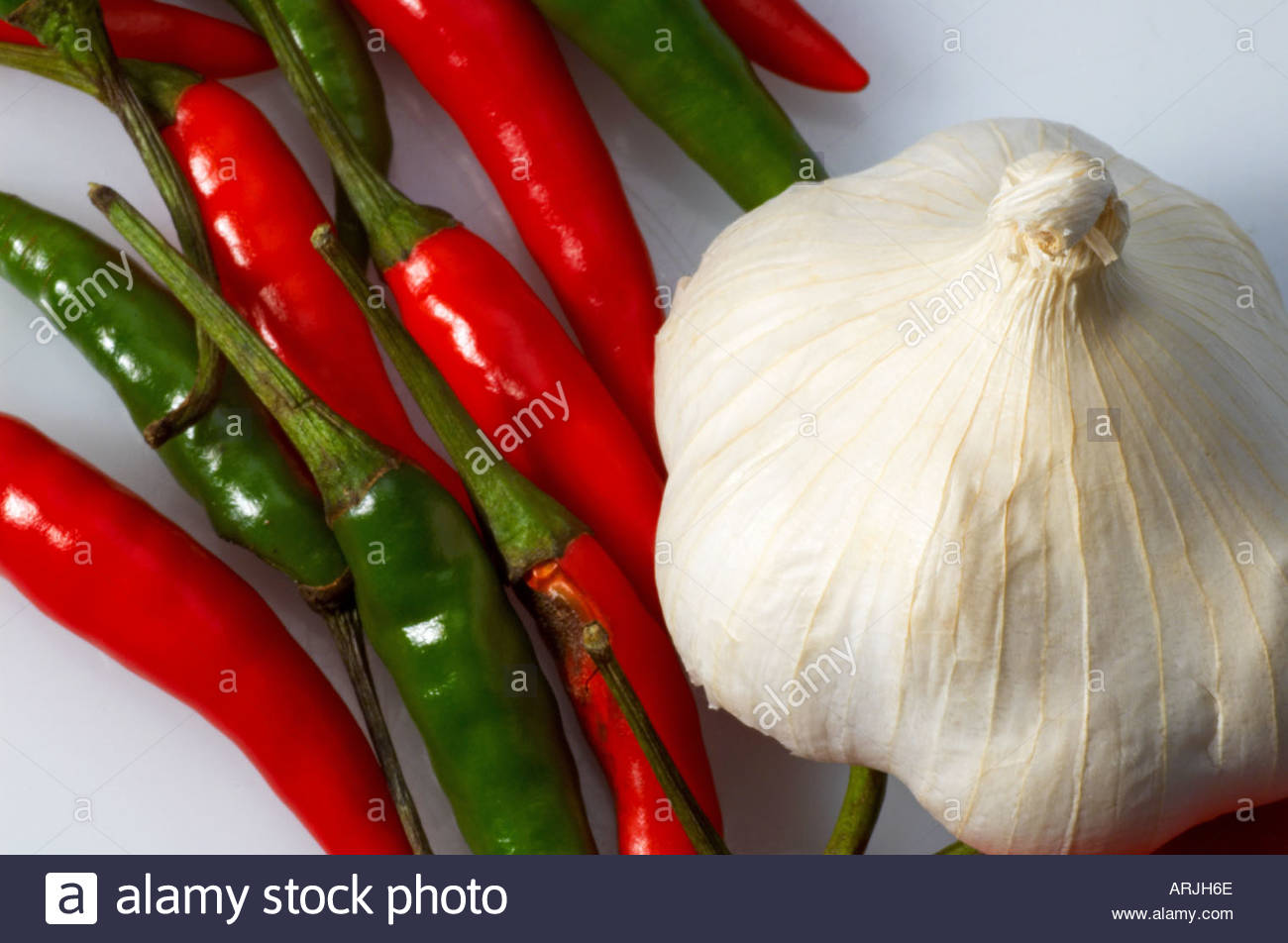 A garlic bulb and birdseye chillies Stock Photo