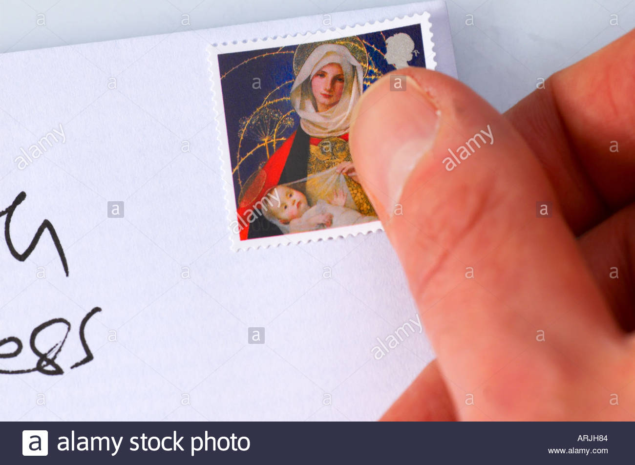 Placing a Christmas first class stamp on a envelope Stock Photo