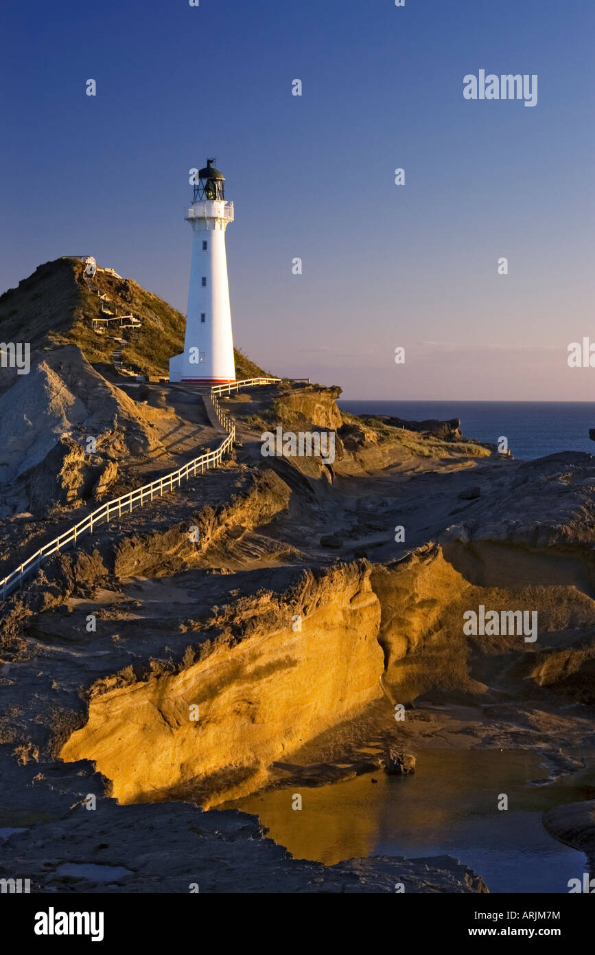 First of the morning sun shines on the lighthouse and cliffs at Castlepoint, Wairarapa, New Zealand Stock Photo