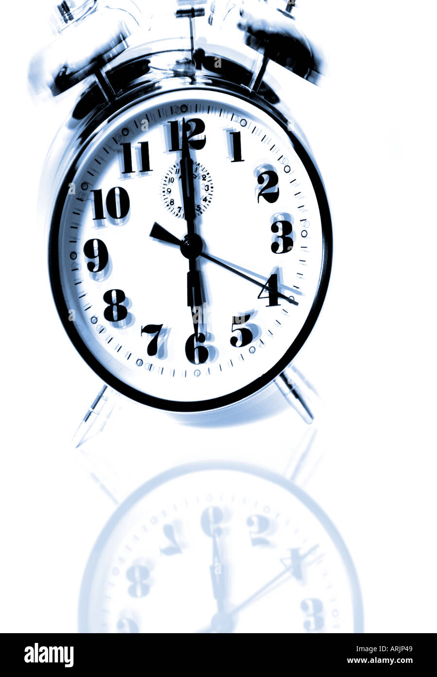 Alarm clock in white reflective surface Stock Photo