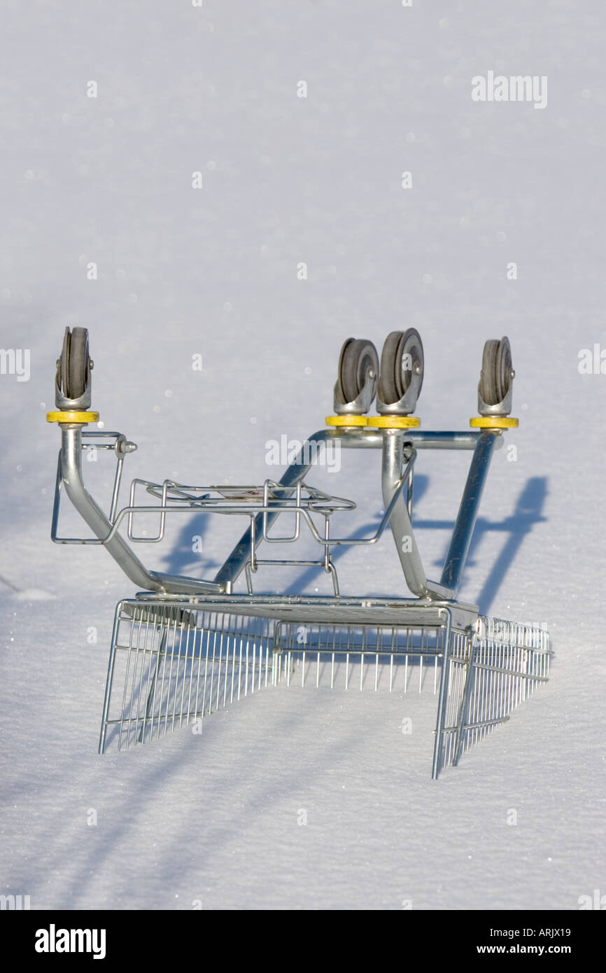 Upturned shopping cart buried to snow , Finland Stock Photo