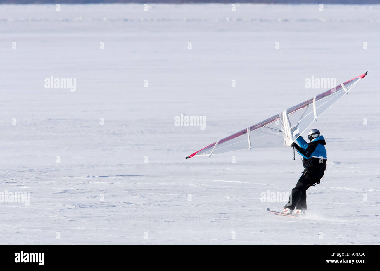 Man skiing on sea ice at Wintertime using a kitewing , Finland Stock Photo