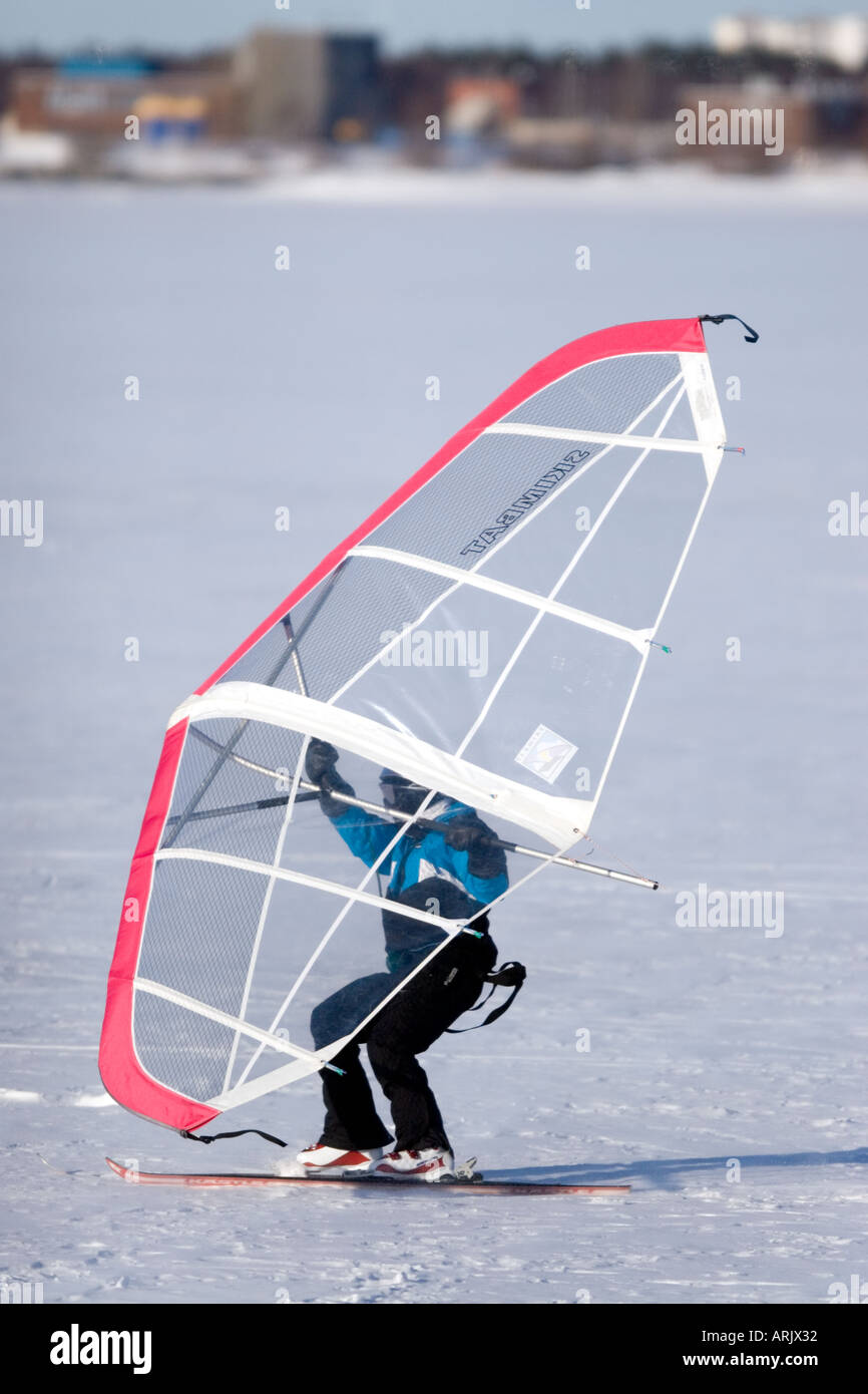 Man skiing on sea ice at Wintertime using a kitewing , Finland Stock Photo
