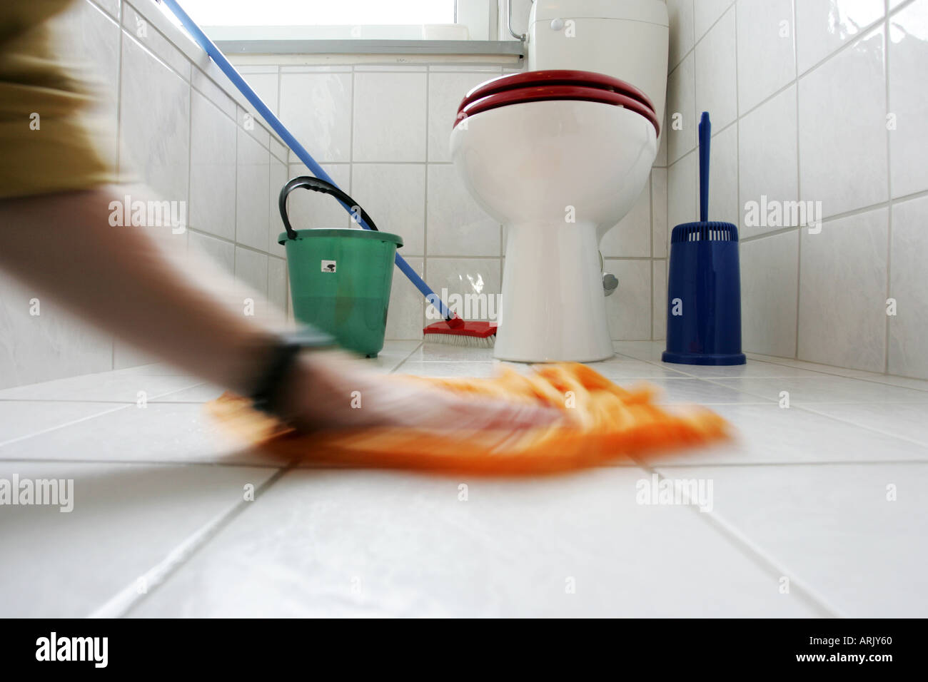 DEU, Germany : Housecleaning in a private house/apartment. Cleaning in the bathroom. Wiping the floor Stock Photo