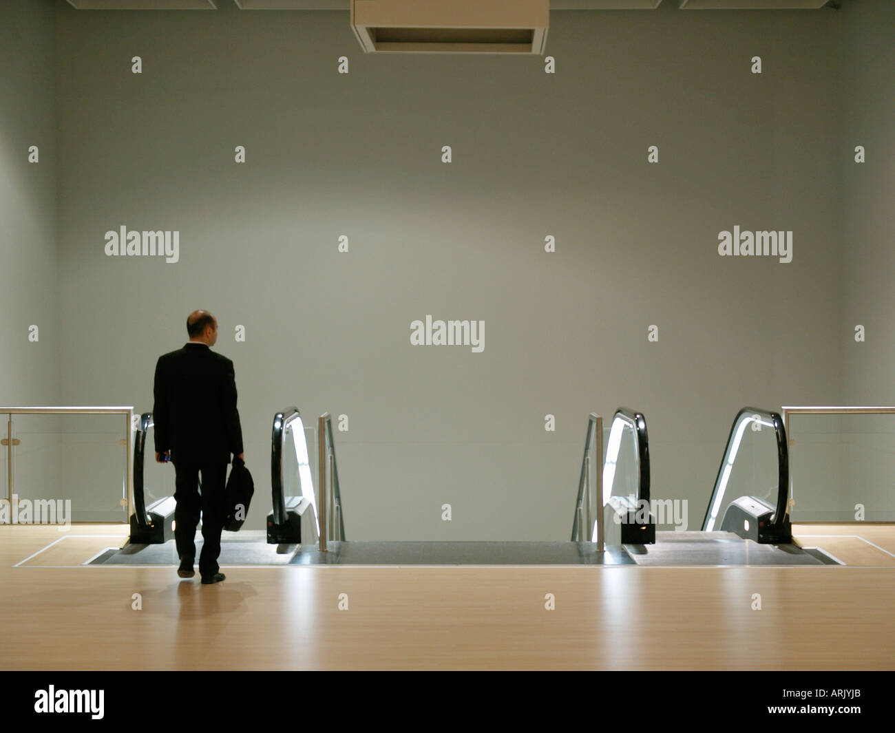 Businessman leaving office business escalator deserted alone boring Stock Photo