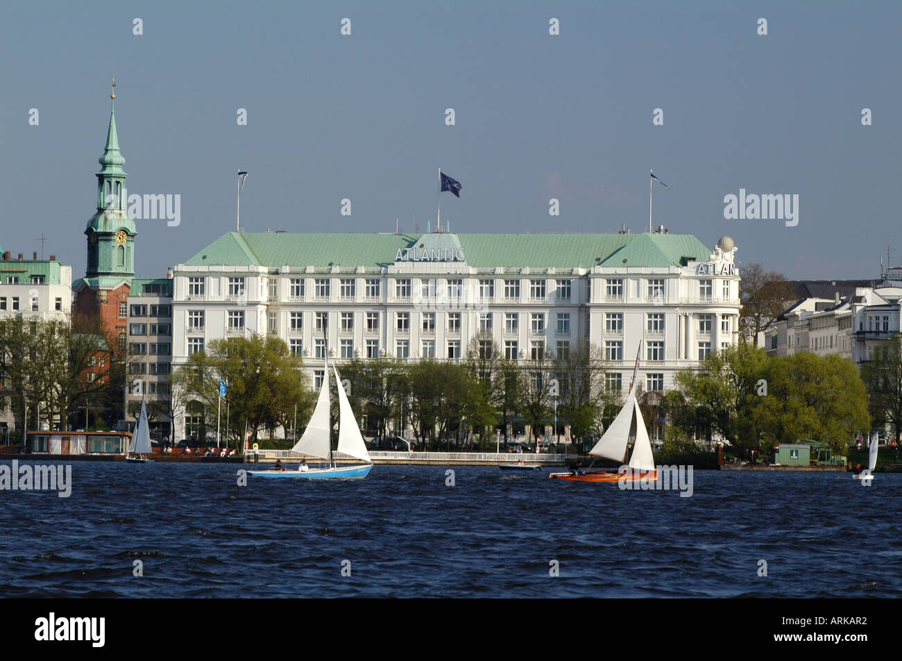 Catboats on the lake Alster in Hamburg, Germany. In the background hotel Atlantic Kempinski and the church of St. Georg. Stock Photo