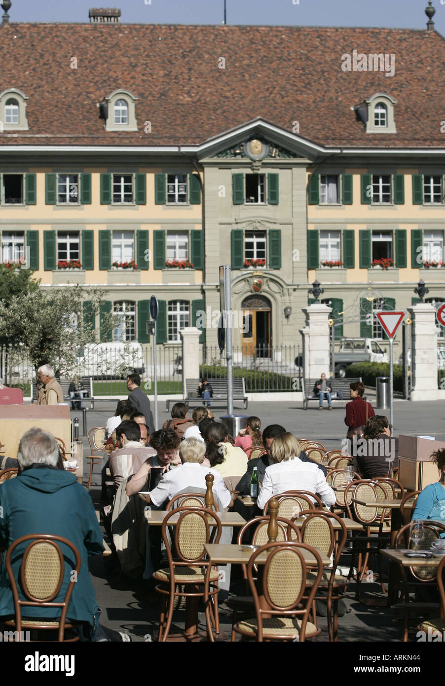 People in a street cafe at the Waisenhausplatz in Berne, in the background the former boys orphanage Stock Photo