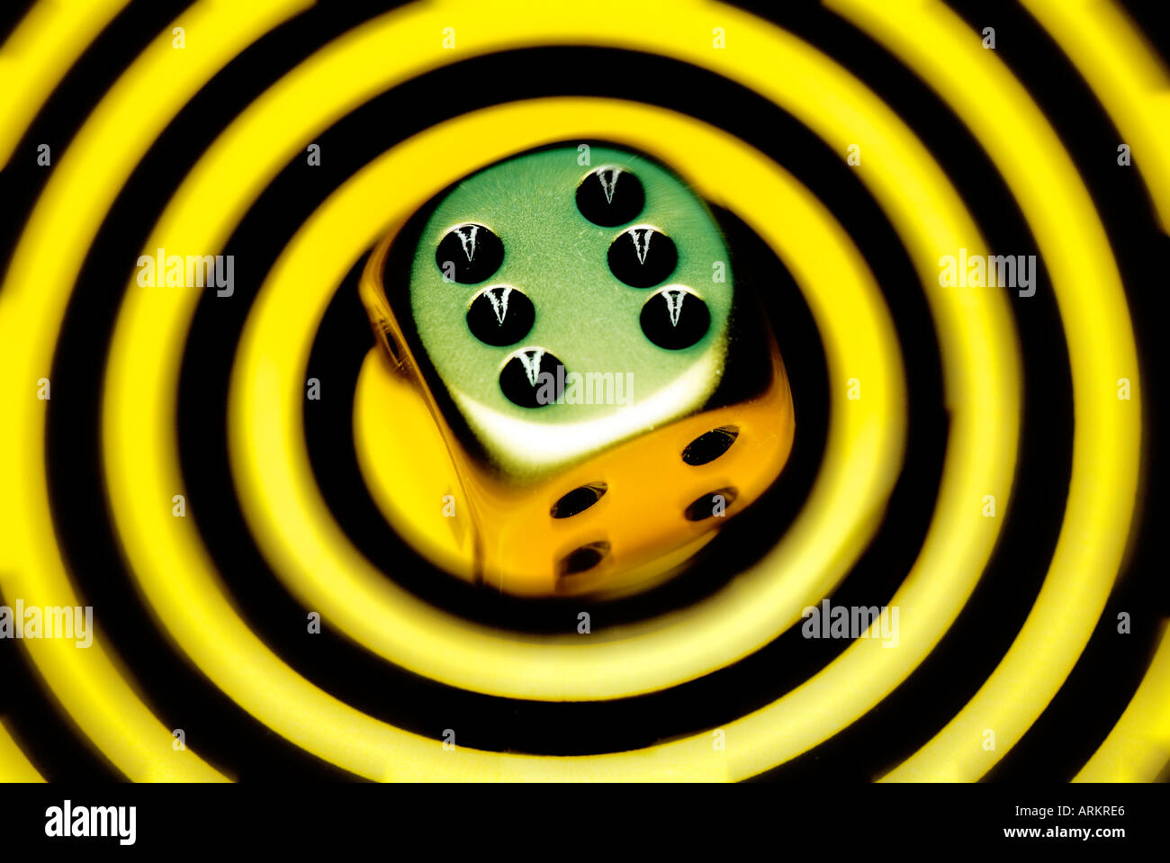 gold die on contemporary yellow circular background Stock Photo