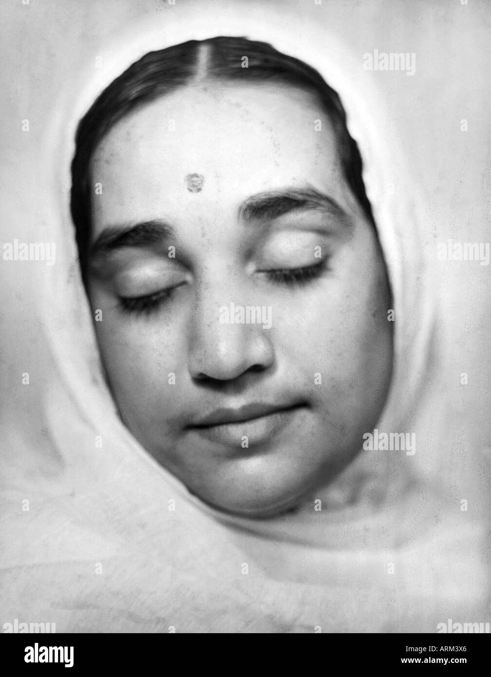 Indian woman with her eyes closed bindi forehead head covered Stock Photo