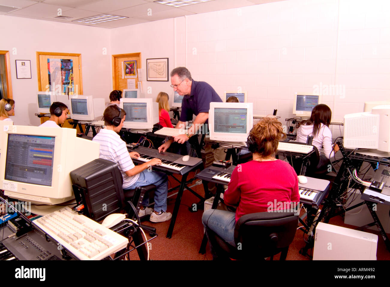 Students Learning Electronic Keyboard from Music Teacher Stock Photo