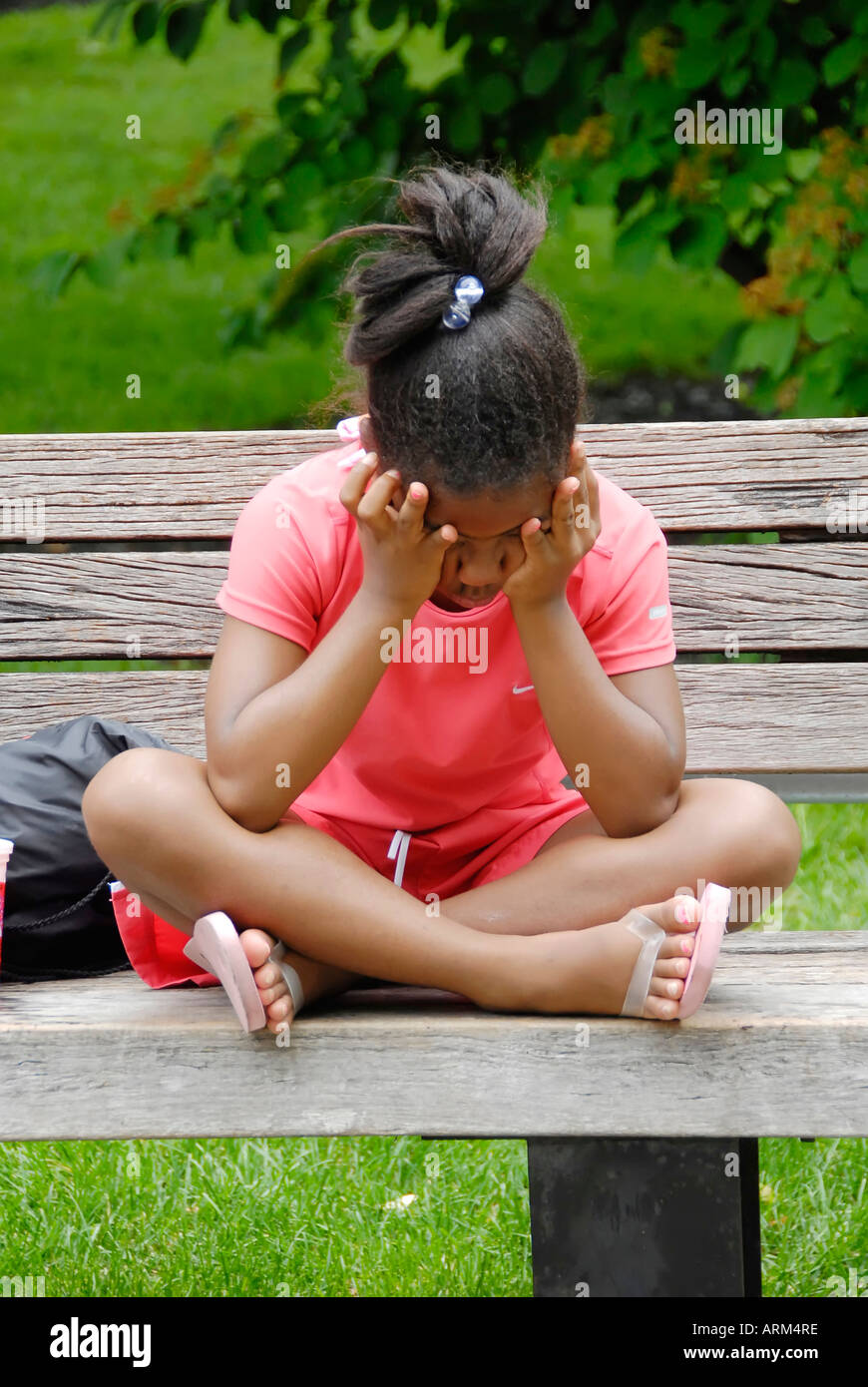 Depressed girl sits on a bench Stock Photo