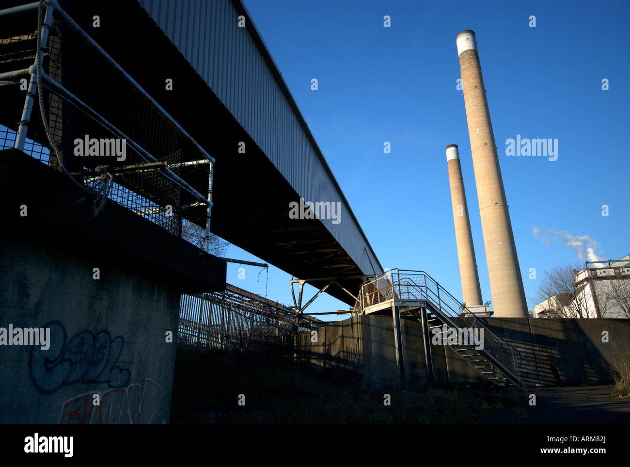 Smoke stack and sea wall at Tilbury power station in Essex. Stock Photo