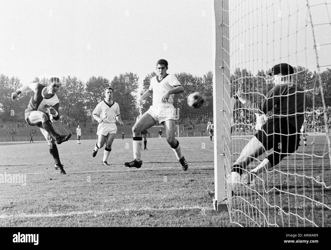 football, WFV Cup, 1965/1966, Fortuna Duesseldorf versus ETB Schwarz-Weiss Essen 1:0, Rhine Stadium in Duesseldorf, scene of the match, f.l.t.r. Peter Meyer (Ddorf) shots on goal, Willi Ridder (ETB), Hans Huelsmann (ETB), keeper Hermann Merchel (ETB) Stock Photo