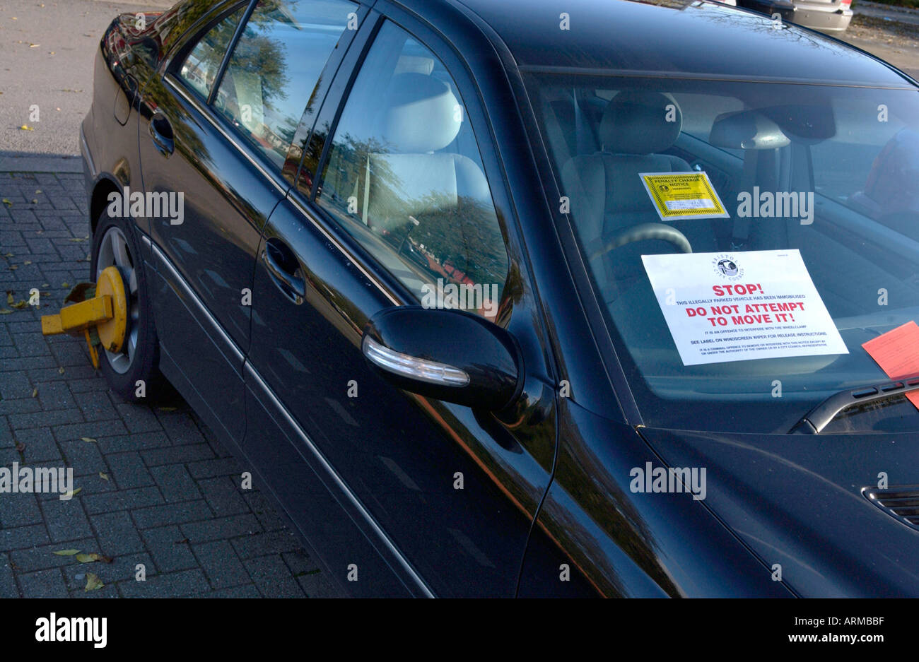Illegally parked car with parking ticket sticker and penalty notice