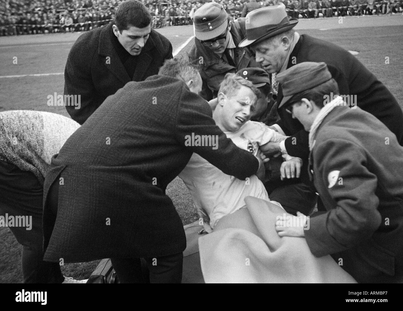 football, Bundesliga, 1966/1967, Rhine Stadium Duesseldorf, Fortuna Duesseldorf versus Borussia Moenchengladbach 2:2, injured football player, Berti Vogts (MG) lies on a stretcher and is  in pain, the helpers are f.l.t.r. masseur Charly Stock (covered), a Stock Photo