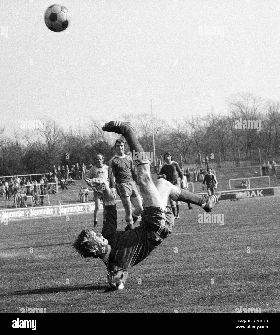 football, Regionalliga West, 1973/1974, Niederrhein Stadium in Oberhausen, Rot-Weiss Oberhausen versus Westfalia Herne 5:0, scene of the match, artistic overhead kick by Ditmar Jakobs (RWO), behind f.l.t.r. a Herne player, Paul Scheermann (RWO) and Dieter Stock Photo