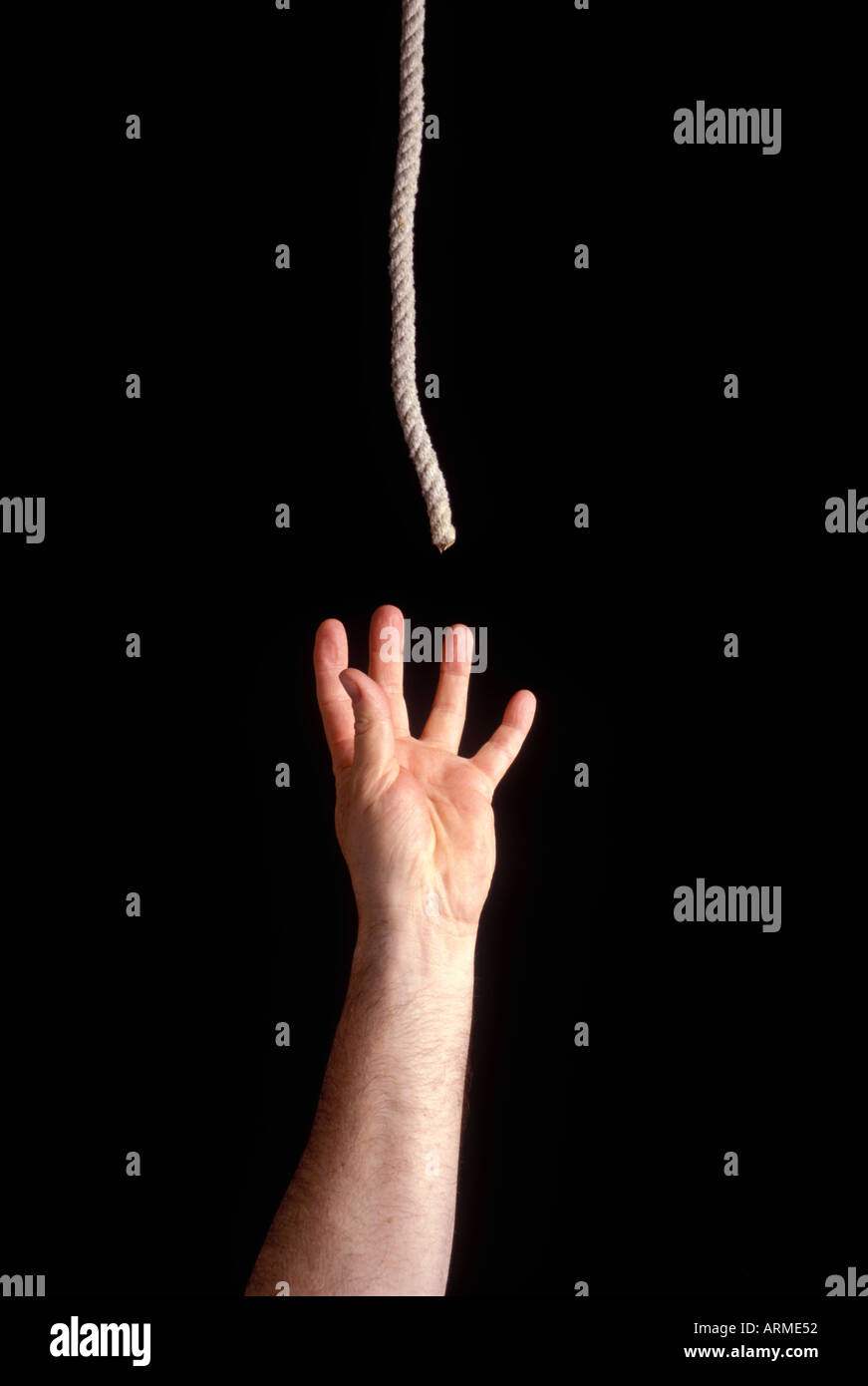 A man s and reaching for rope at the end of your rope Stock Photo Alamy