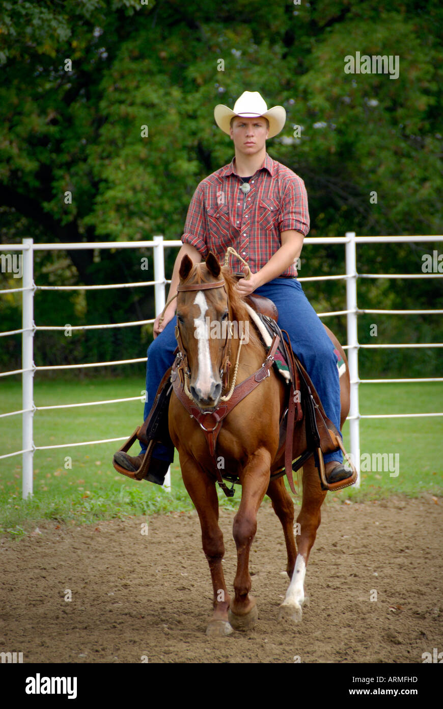 Male High school student riding a brown horse competes in equestrian event Stock Photo