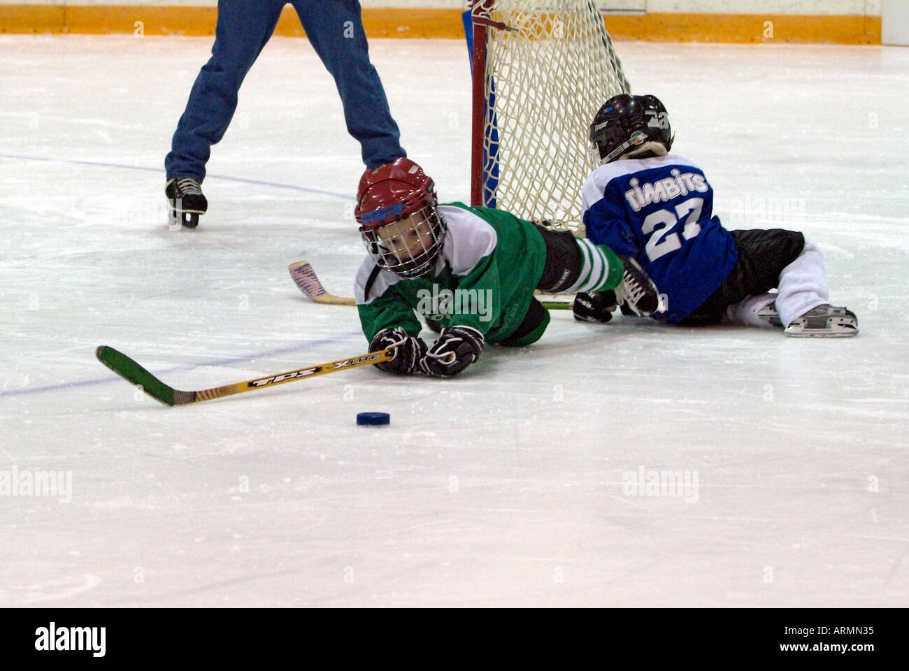 5 year old boys learn how to play the game of ice hockey Stock Photo