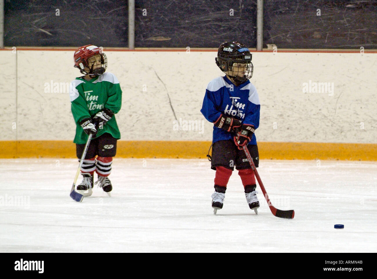 5 year old boys learn how to play the game of ice hockey Stock Photo