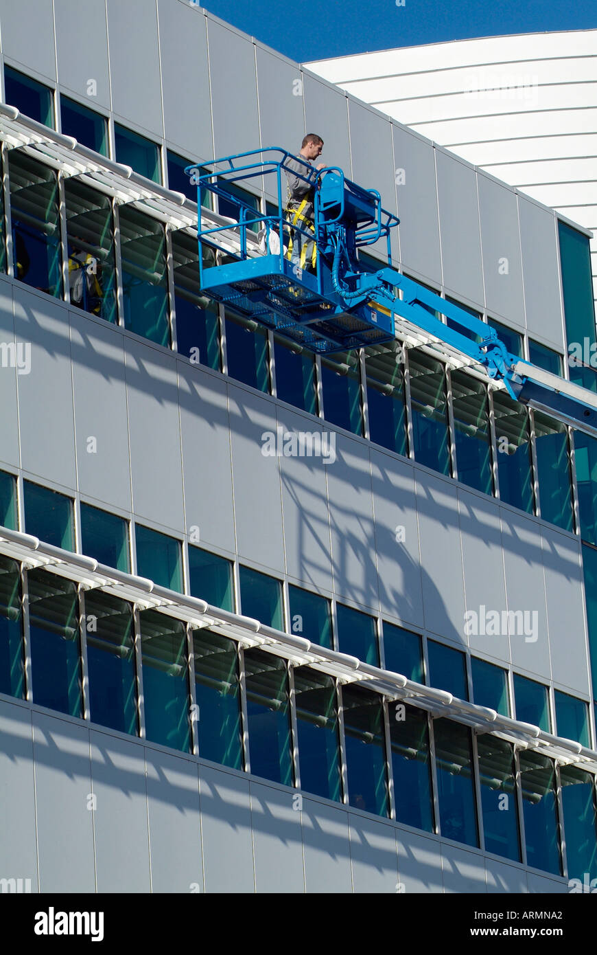 Window washers use mechanical industrial boom to elevate them against