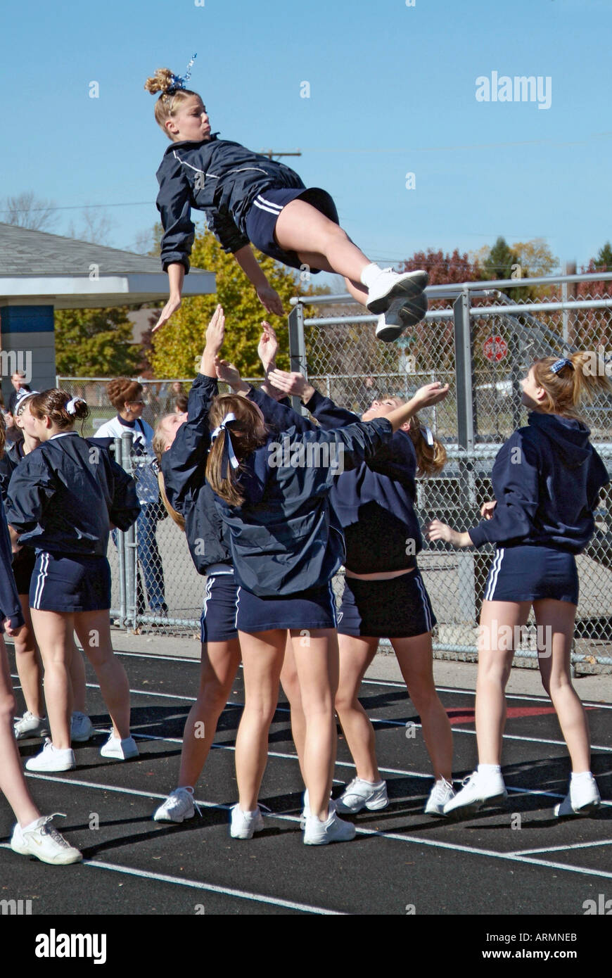High School cheerleaders perform complicated and sometimes dangerous maneuvers during presentation at a football game Stock Photo