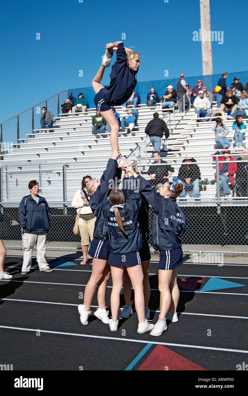 High School cheerleaders perform complicated and sometimes dangerous maneuvers during presentation at a football game Stock Photo