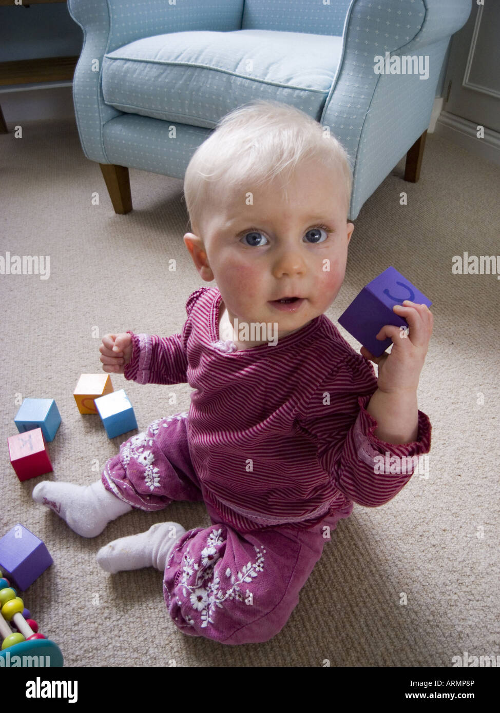A 10 month old baby playing with wooden block toys Stock Photo Alamy