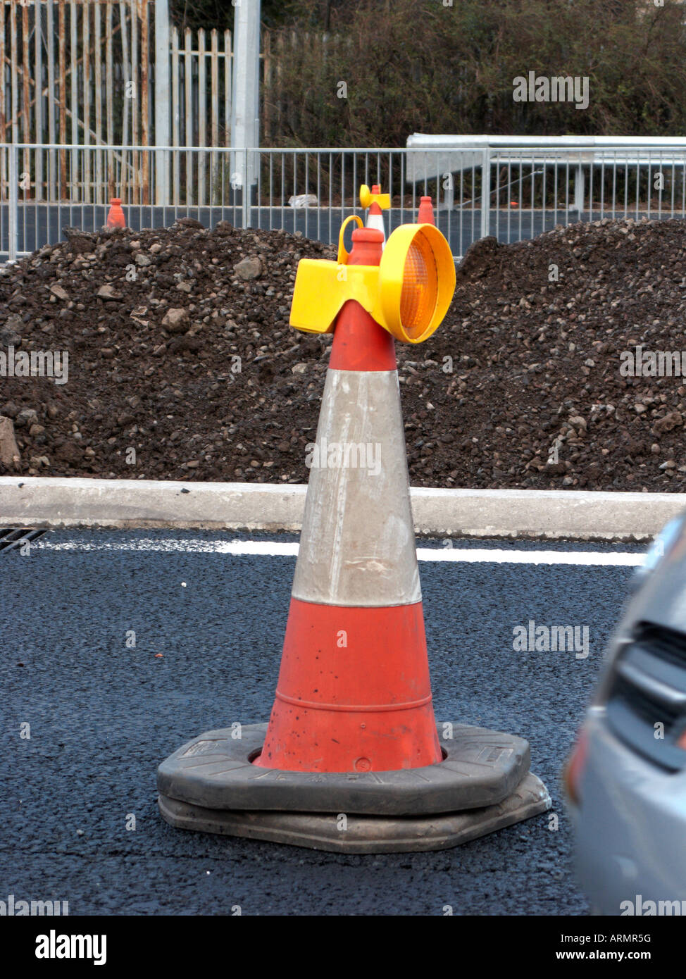 traffic cone with guide light on top at roadworks in new section of motorway with car passing belfast Northern Ireland UK Stock Photo