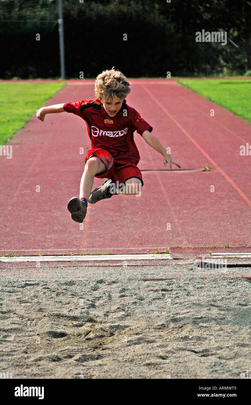 Young boy doing long jump at an athletics track Stock Photo Alamy