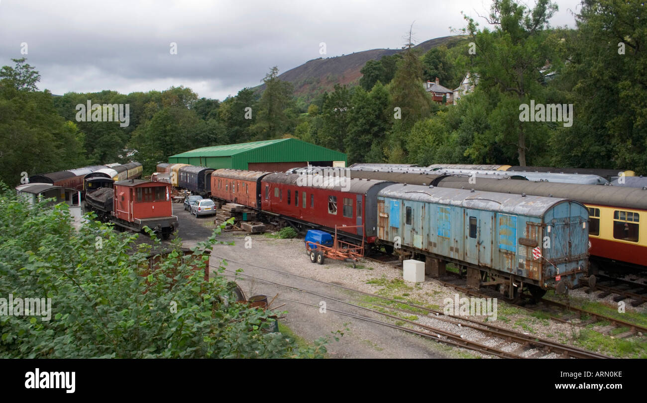 A collection of old style vintage railway carriages and wagons in the sidings waiting to be restored. Wales, UK. Stock Photo