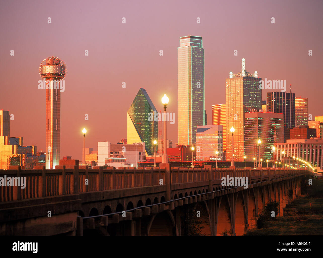 Dallas skyline in sunset light over viaduct with Reunion Tower on left ...