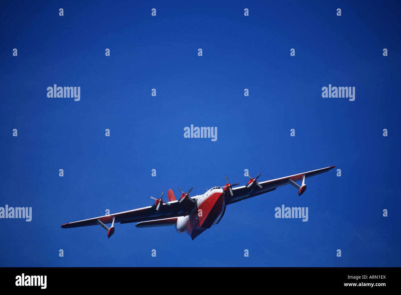 Martin Mars water bomber flying with blue sky, British Columbia, Canada