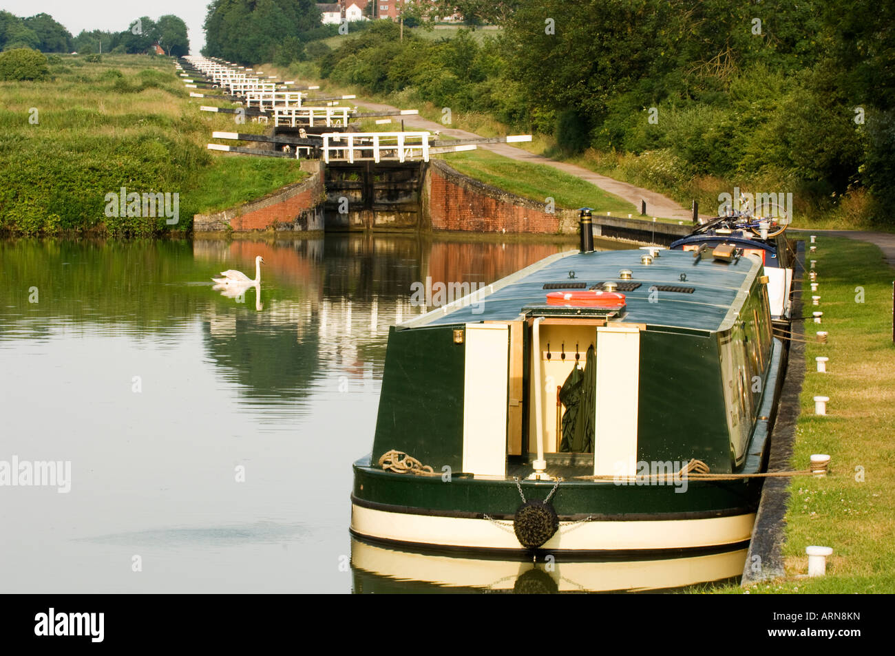 Traditional English Narrow boats moored at the quay  at the bottom of the flight of locks at Caen Hill, Devizes, Wiltshire, UK Stock Photo