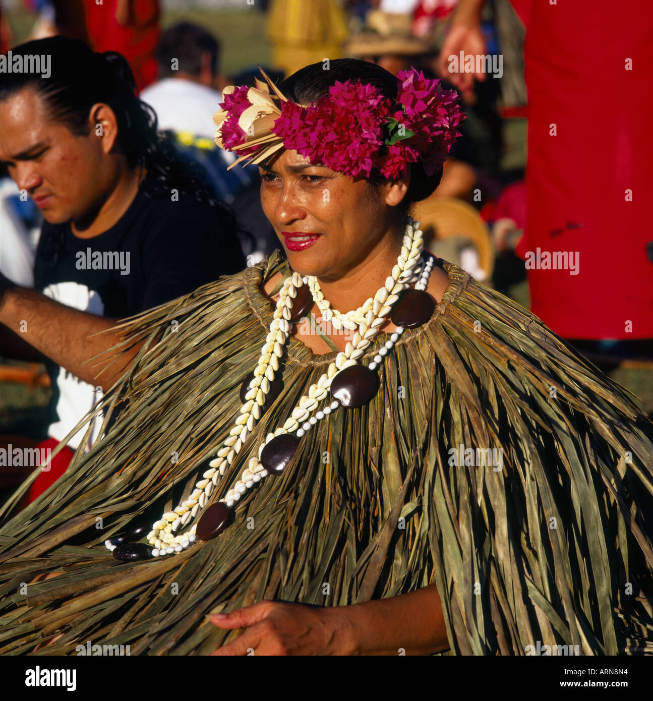 Smiling female dancer from Guam sitting down wearing coconut leaf