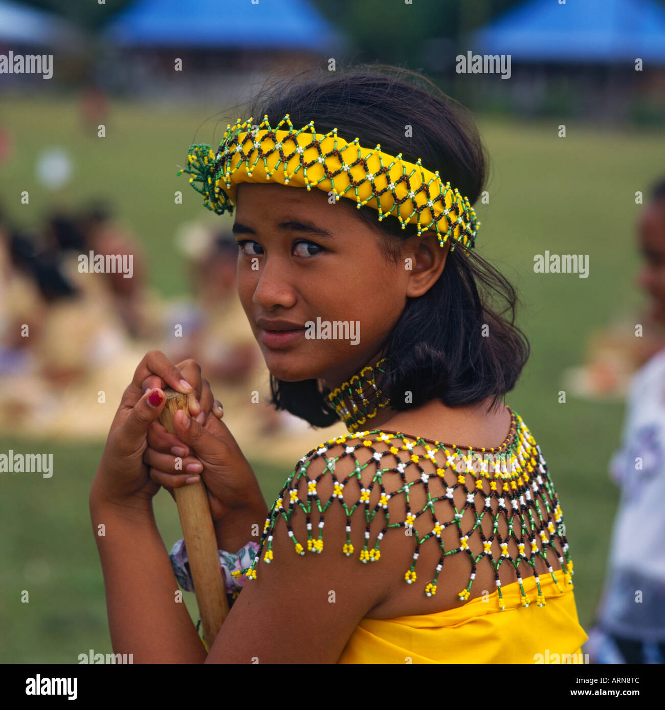Young girl dancer from the Northern Marianas Islands in yellow traditional costume with beaded yolk and head band Stock Photo