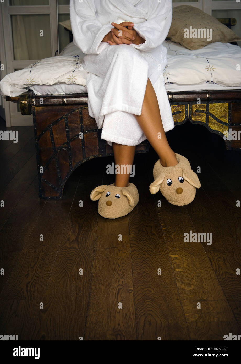 Woman in bedroom with toy slippers Stock Photo