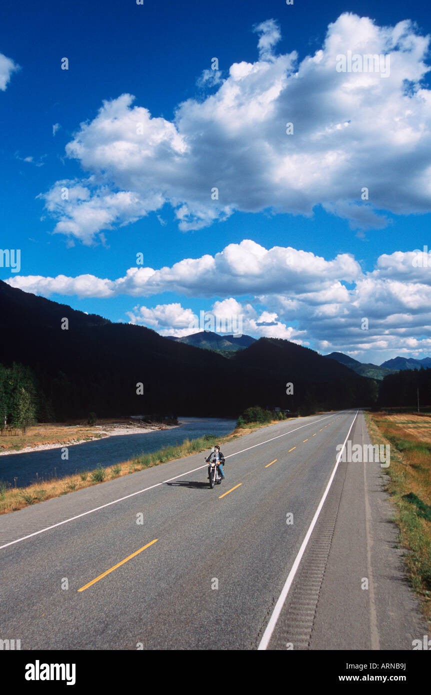 motorcycle rider on road by Elk River at Morrisey, near Fernie, British Columbia, Canada. Stock Photo