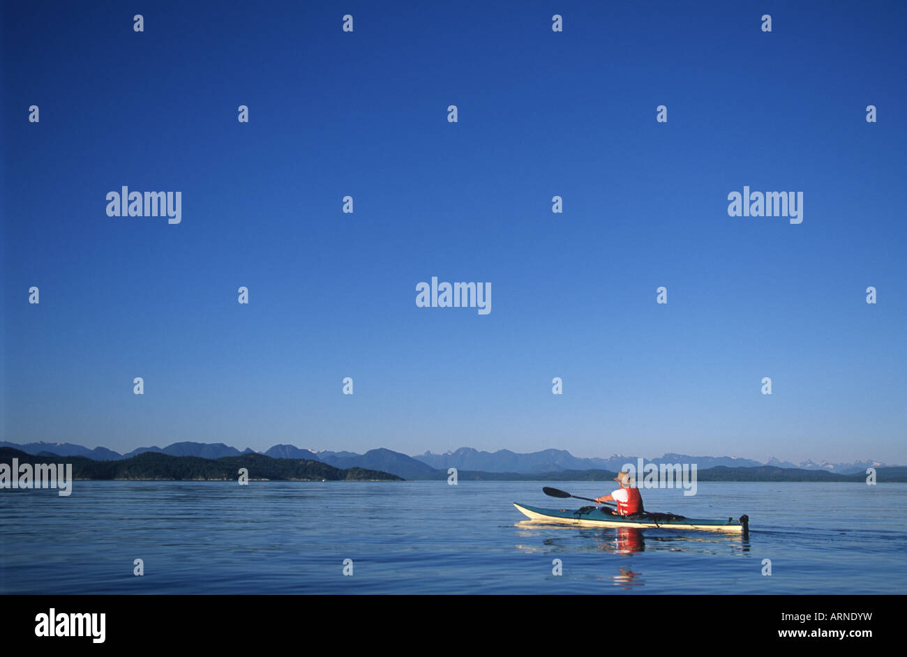 kayaker paddles to breton islands from Rebecca Spit, British Columbia, Canada. Stock Photo