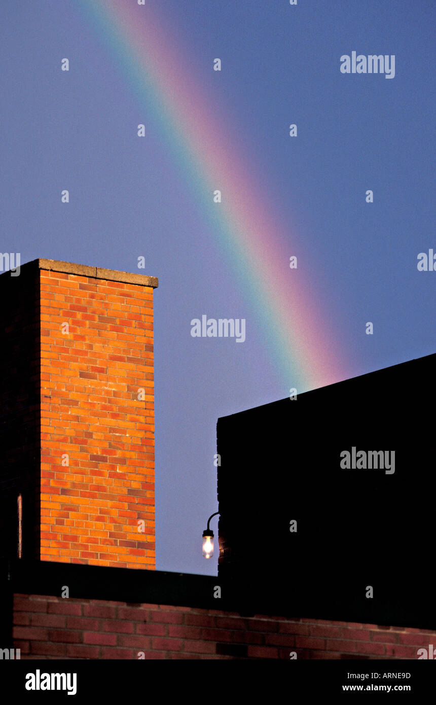 Under the rainbow Rainbow over industrial brick buildings Stock Photo