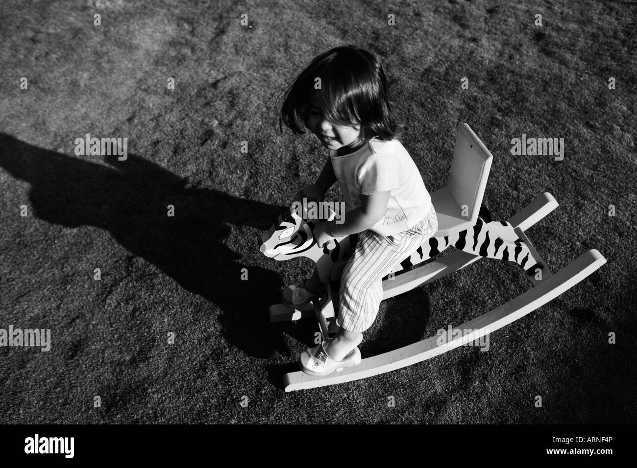 Girl on tiger rocking horse Stock Photo Alamy